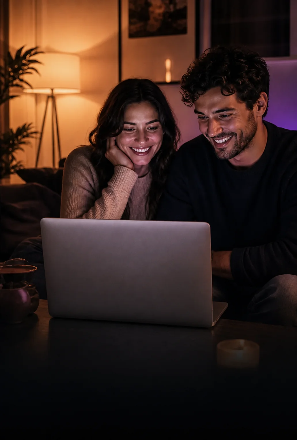 Two clients lit by their laptop screen as they enjoy the finished project together